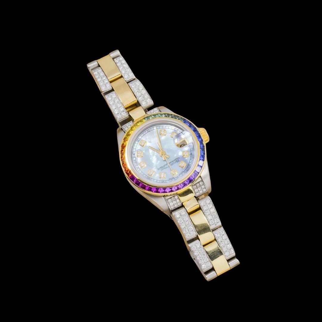 Rolex Datejust Blue Pearl Dial Rainbow Bezel Two Tone Yellow Gold Semi Iced Oyster Bracelet Moissanite Watch Close Up Front View